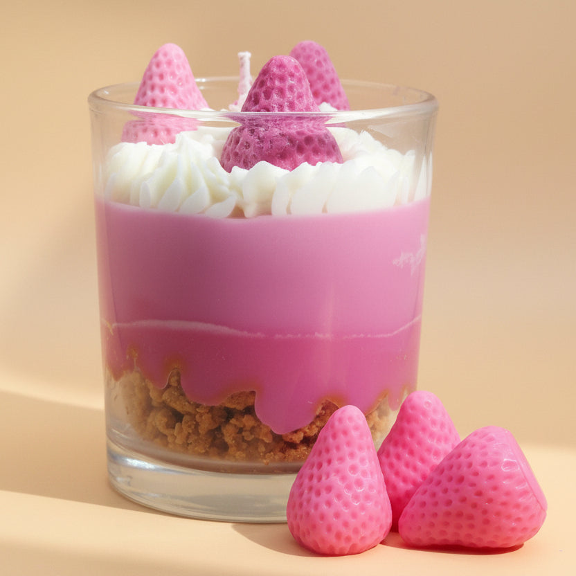 Detail van handgemaakte geurkaars Strawberry Cheesecake met romige topping en aardbei wax decoratie.