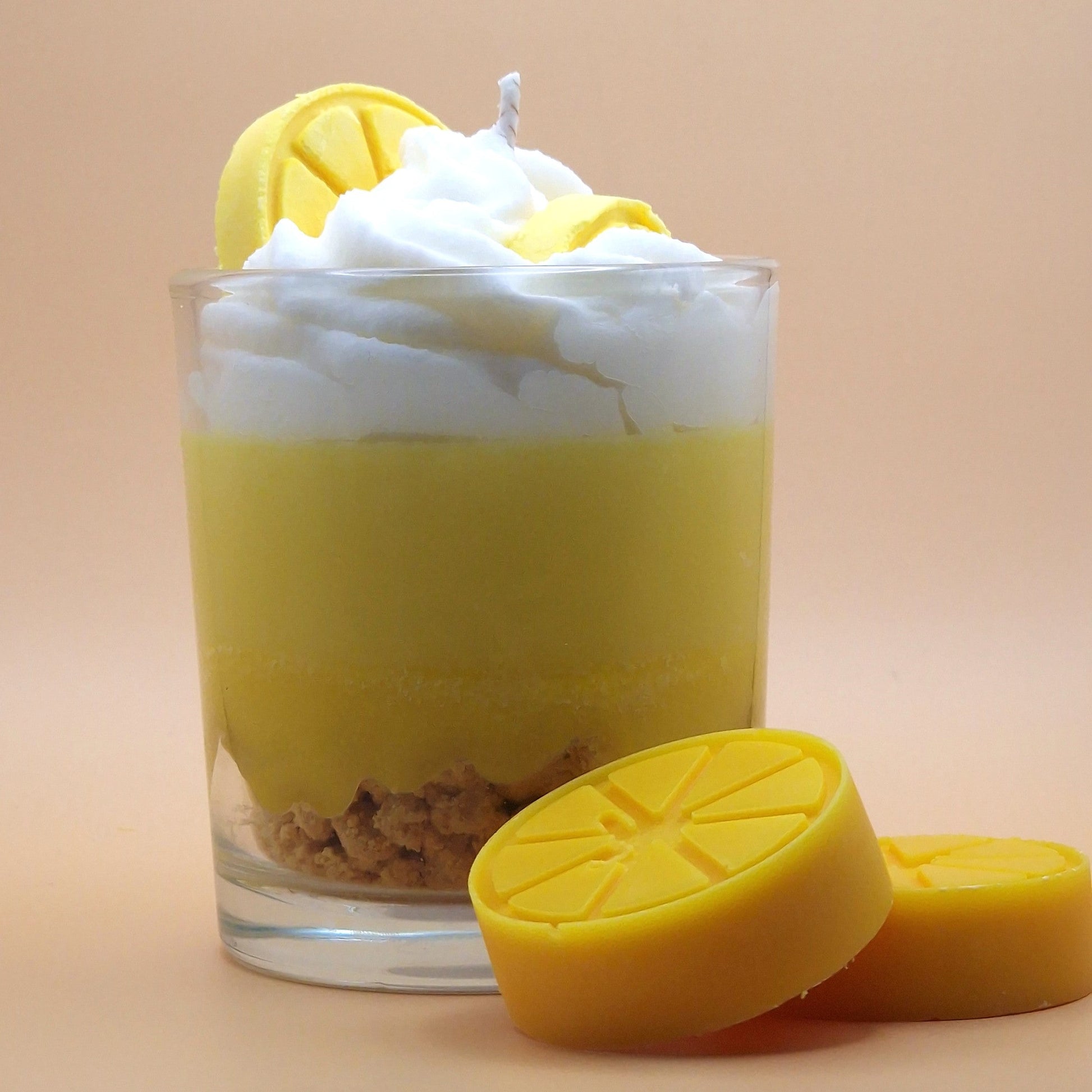 Glass dessert with lemon layers and whipped cream on a beige background