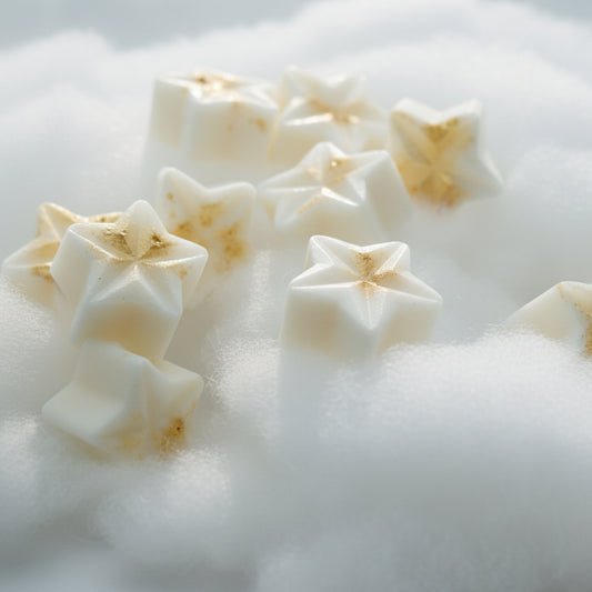 Witte Golden Stars wax melts in stervorm met goudkleurige accenten op een zachte witte ondergrond.